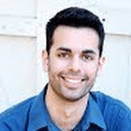 Smiling man with dark hair and a blue shirt. A friendly portrait for a reviews blog.